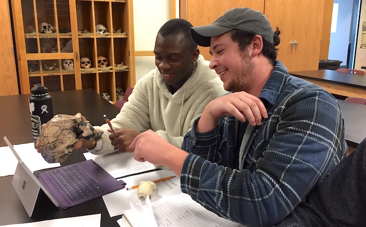 Two students looking at artifacts