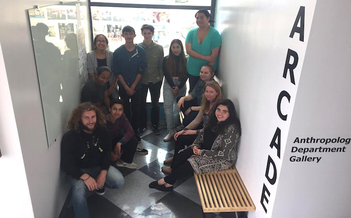 Anthropology students in hallway smiling at camera