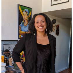Dr. Fischer wearing a black top with a painting of Dr. Faye Harrison in blue along with black, green , gold colored Jamaican flag; this photo was taken by Dr. Faye V Harrison editor of Decolonizing Anthropology an author of Outsider Within: Reworking Anthropology in a Global Age