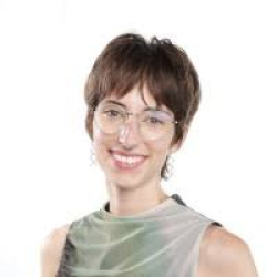 Elisa smiling with light green top and white background