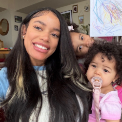 Professor Henderson in blue  with family in pink  and daughters' drawings in frame