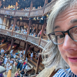 Dr. Bakker Kellog taking a selfie at a historic site , looks like a theatre with a crowd